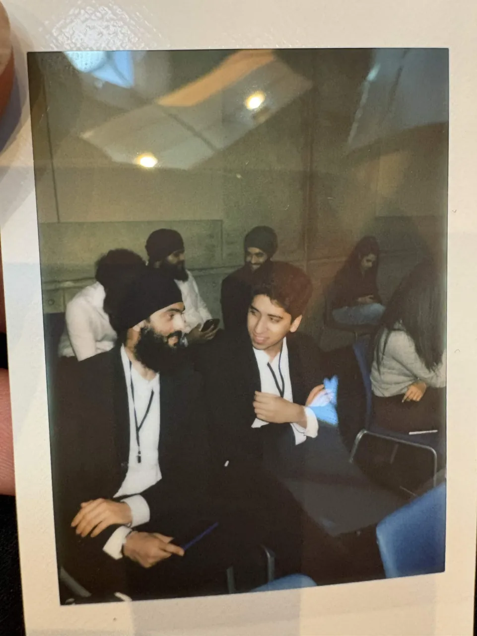 A printed photograph of Arjen and a friend talking at a conference.